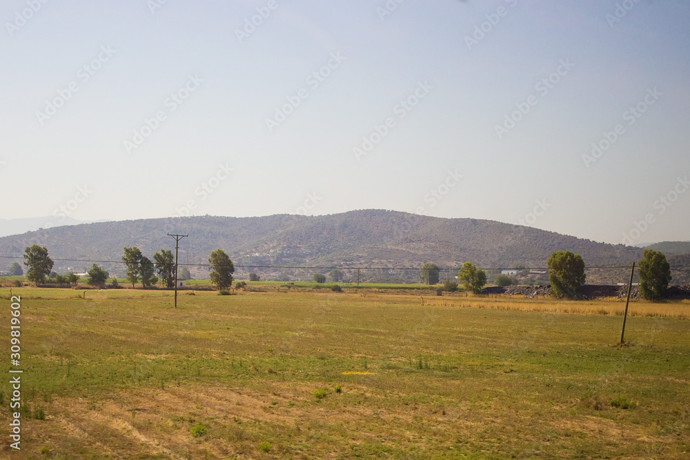 Beautiful view on yellow hills and grassland with green trees, stone rocks in Bodrum, Mugla, Turkey. Travel and vacation concept