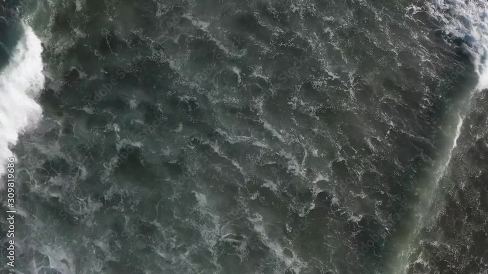 Top down drone aerial view of swirling dark blue ocean water as waves pass underneath the camera Top down drone aerial view of swirling dark blue ocean water as waves pass underneath the camera