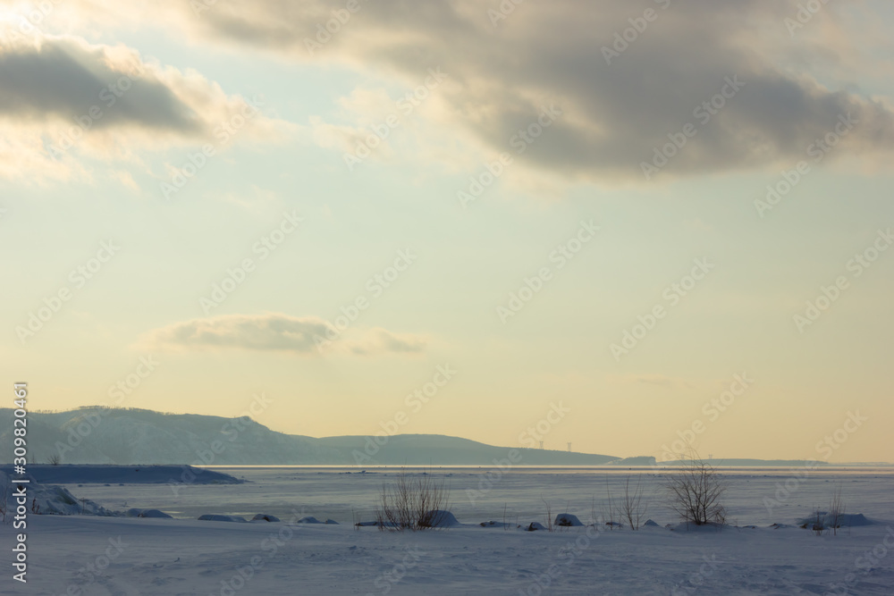 Winter snowy landscape with the plain and the sky Winter snowy landscape with the plain and the sky