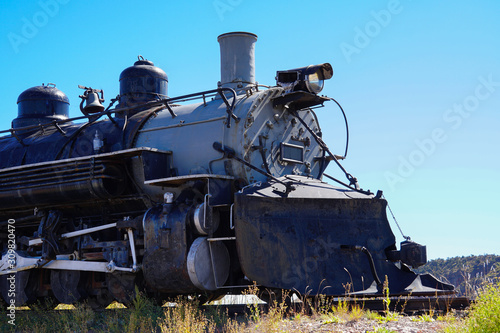 Side view of an old locomotive engine that has seen better days.