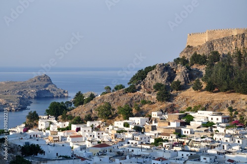 Lindos city on the Rhodos island with white buildings houses and castle on the top mountain rock near the sea ocean 