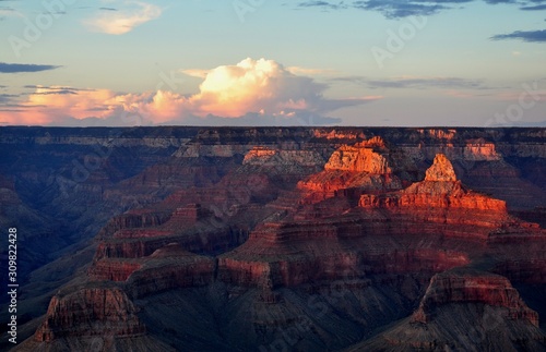 Landscape view Gran Canyon on sunset. Orange colored mountains rocks with big cloud on the sky