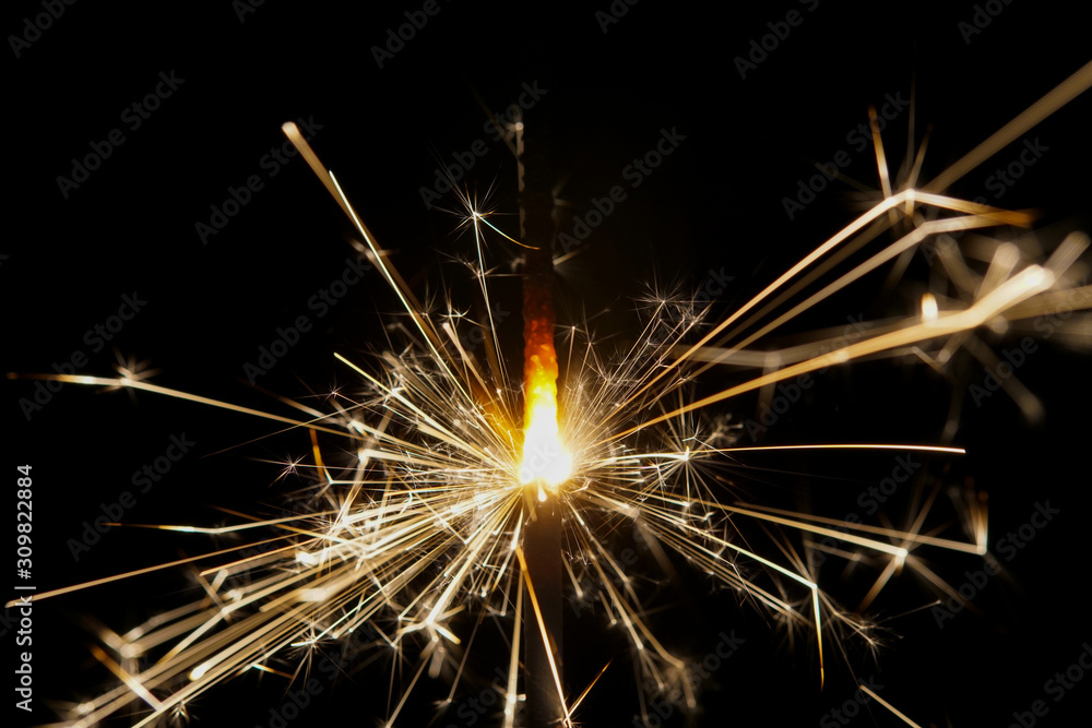 A burning sparkler with black background