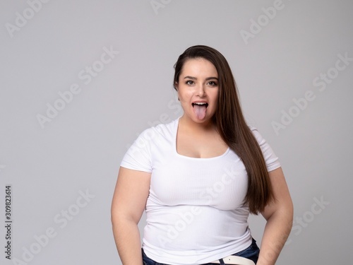 Plus Size Model with long hair Grimacing, pulling her cheeks.
