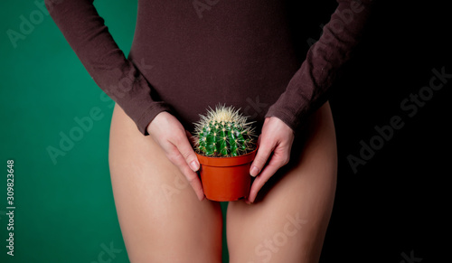 woman holds cactus in her hands at foot level