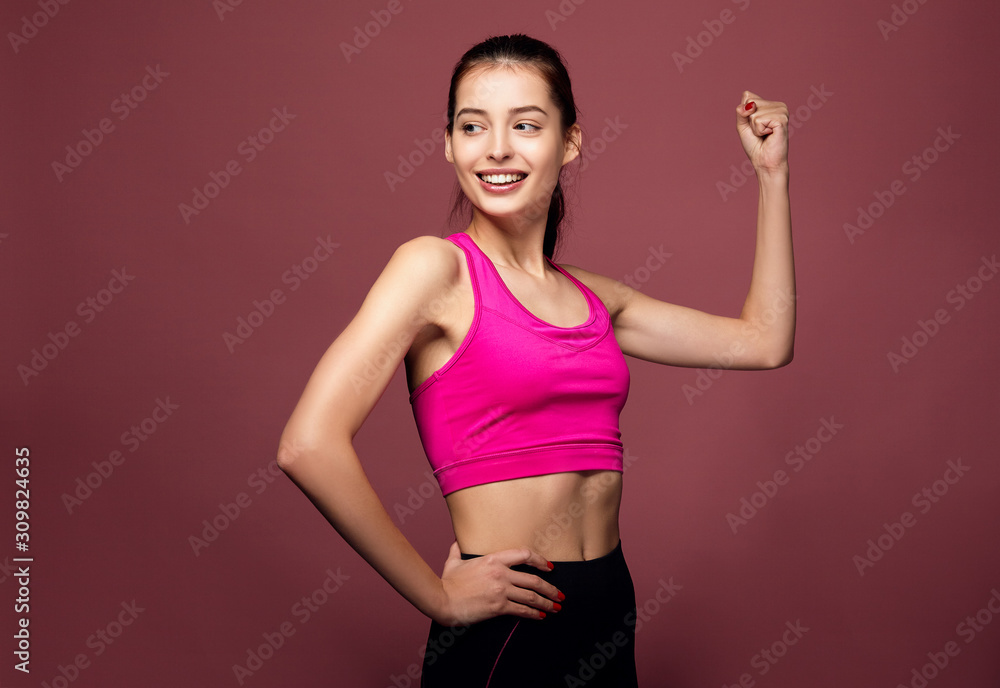 Portrait of a cheerful fitness woman flexing biceps. Portrait of a cheerful fitness woman flexing biceps.