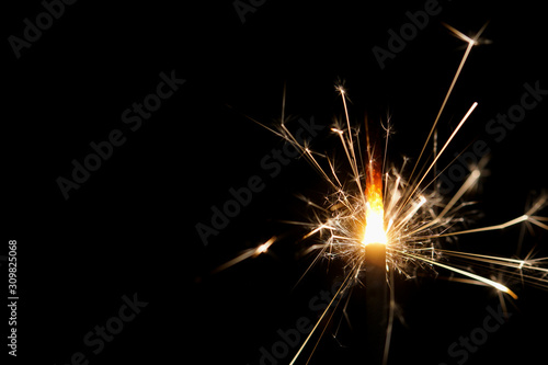 A burning sparkler with black background