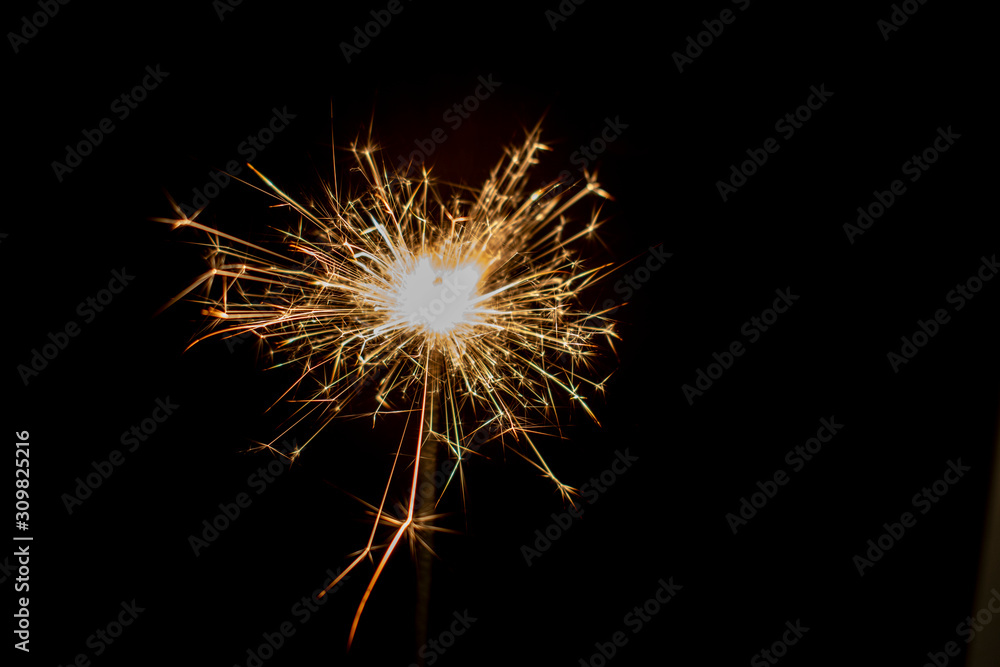 Sparkling sparkler on a black background. New Year theme..