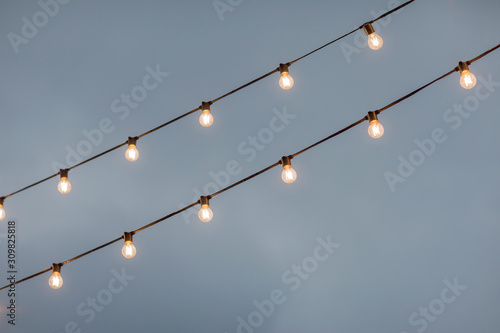 lamp light bulbs on sky background. Christmas street mood