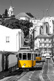 Yellow tram on old streets of Lisbon, Alfama, Portugal. Black and white picture with a coloured tram.