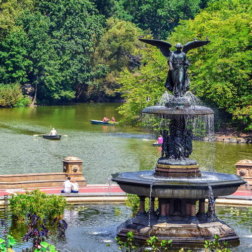 People relaxing and enjoying  a sunny day in Central Park at  Bethesda fountain. Free time leisure and travel concept. New York City. United States