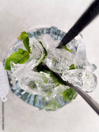 Verre de Mojito vu du dessus en gros plan avec des feuilles de menthe et des glaçons