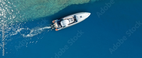 Aerial drone ultra wide top down photo of luxury rigid inflatable speed boat cruising in high speed in Aegean deep blue sea, Greece © aerial-drone