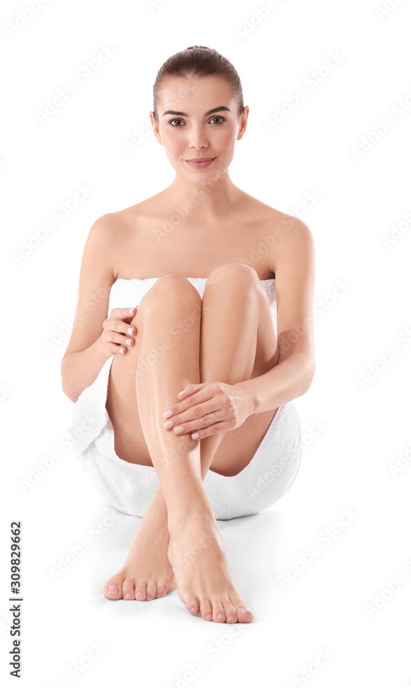 Fototapeta premium Beautiful young woman wrapped in towel on white background