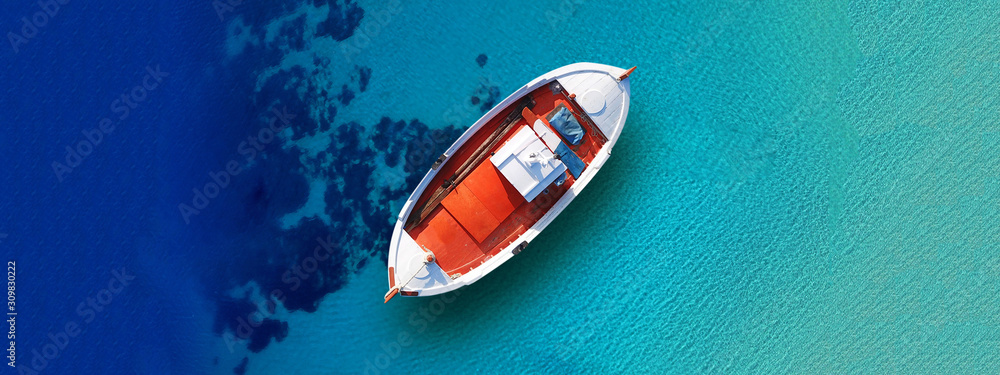 Fototapeta premium Aerial drone top down ultra wide photo of traditional picturesque wooden fishing boat in Crete island beach with turquoise sea, Greece