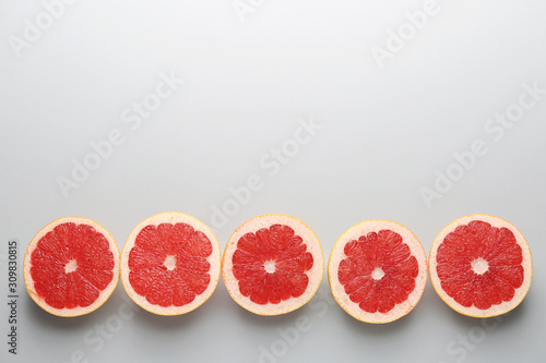 Fresh cut grapefruit on light background