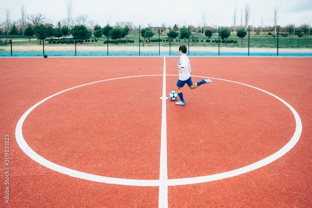 Fototapeta premium Soccer player boy hitting the ball