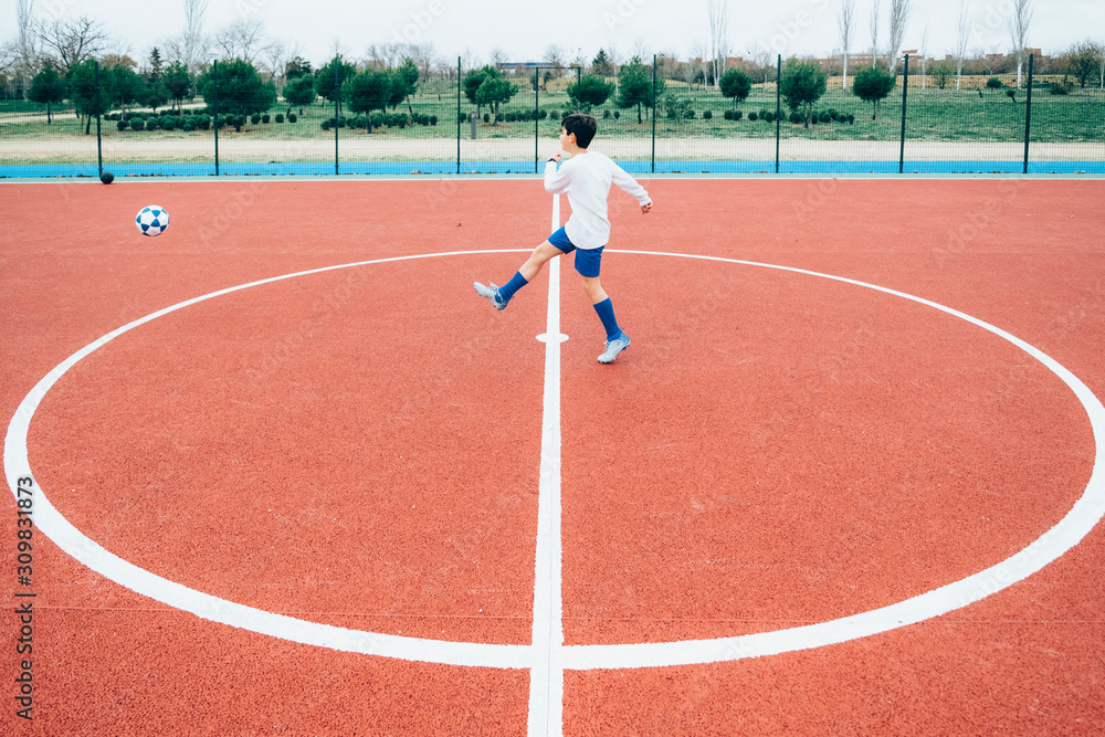 Fototapeta premium Soccer player boy hitting the ball