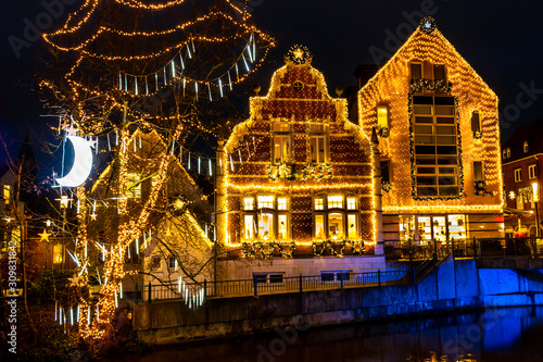 Christmas fair in the evening with lots of yellow colored christmas lights at the buildings in the city Nordhorn country Germany