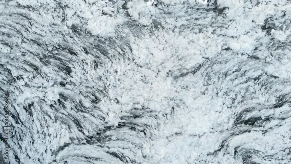 Aerial view of a frozen river. Fancy ice texture, cold chained water. Shards of ice stick out with sharp edges.