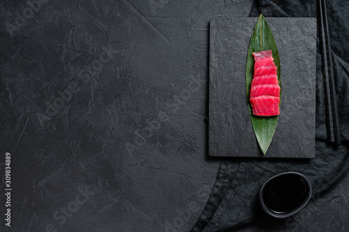 sashimi tuna on a stone Board. Black background. Top view. Space for text