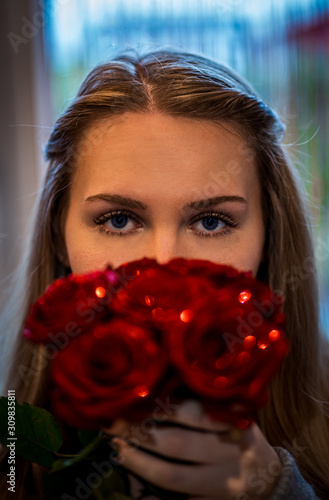 Glitzer Rosen vor einem Frauengesicht mit Bokeh  und blauen Augen © picturelens
