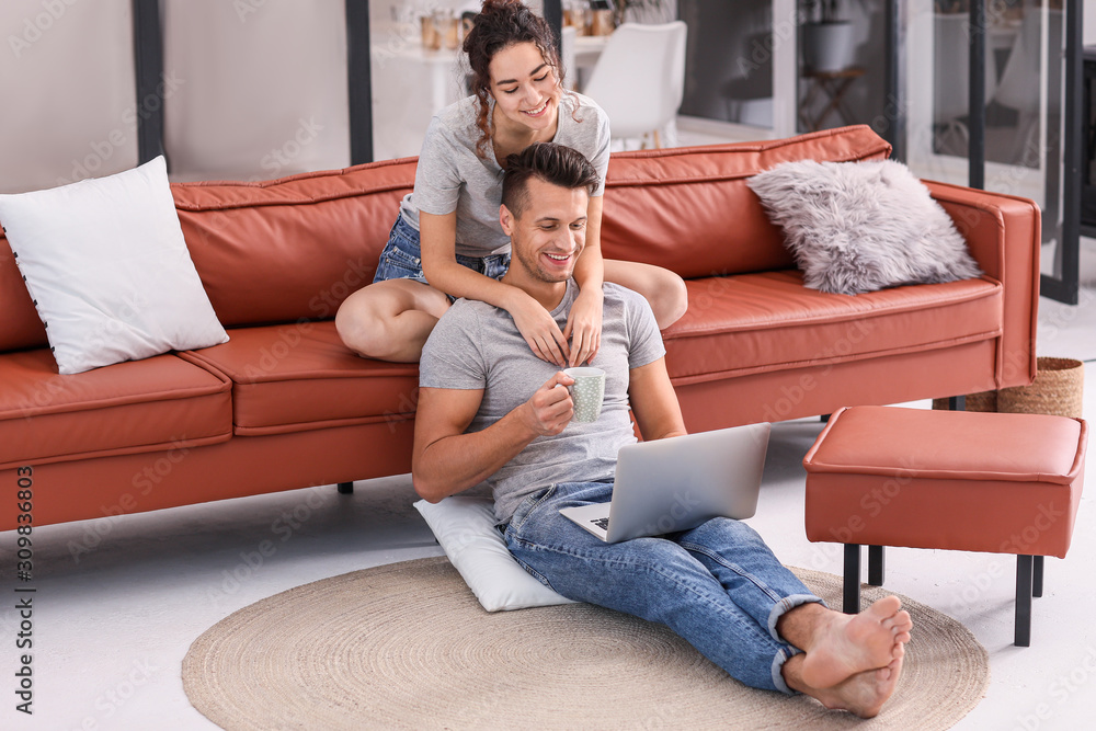 Obraz premium Happy young couple with laptop at home