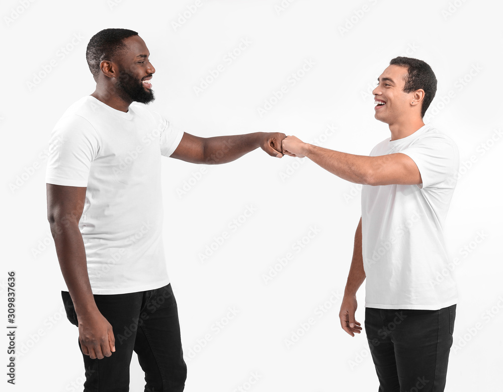 Portrait of young African-American men bumping fists on white background Portrait of young African-American men bumping fists on white background