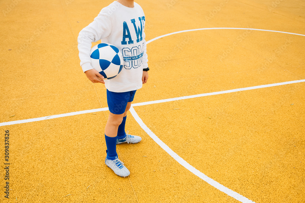 Obraz premium Portrait of soccer player boy with ball in his arm