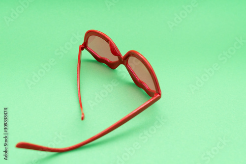 red plastic glasses on green background