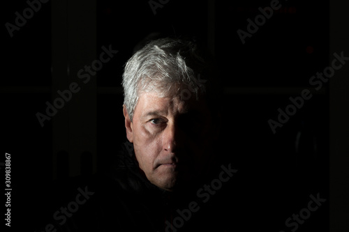 chiaroscuro portrait of a white-haired man