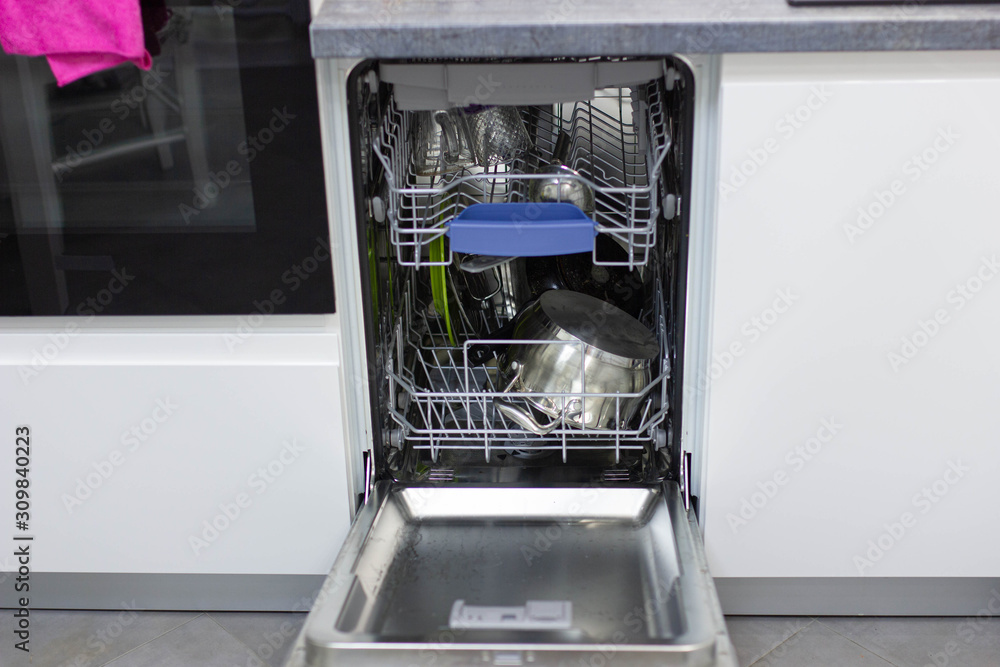 dishwasher in a white cupboard in a modern kitchen. dishwasher in a white cupboard in a modern kitchen.