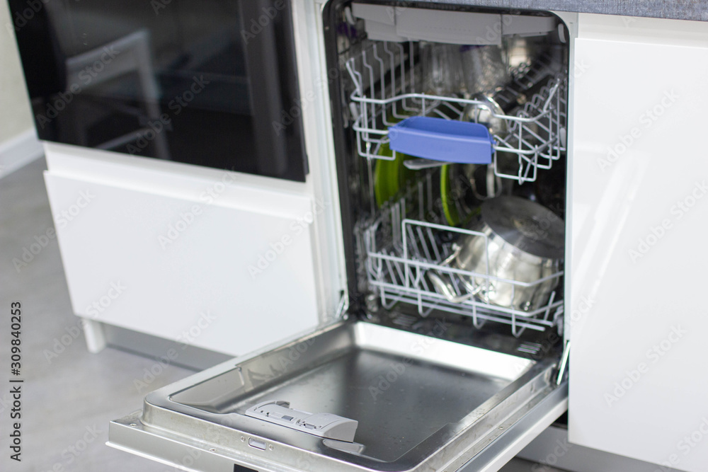 dishwasher in a white cupboard in a modern kitchen. dishwasher in a white cupboard in a modern kitchen.