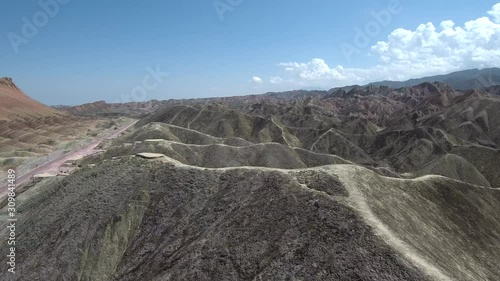 Flying over the Zhangye Danxia Landform Geological Park known also like the rainbow mountains with its colorful hills and clear blue sky in the background in Gansu province, China.