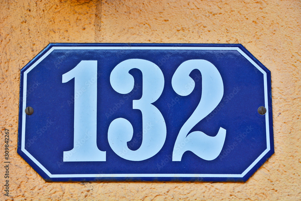 Obraz premium A house number plaque, showing the number one hundred thirty two (132)