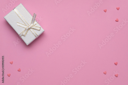..Romantic concept for Valentine`s Day. Flat lay. Pattern of pink hearts on a pink background and white gift box.  Copy Space. © MIKHAIL