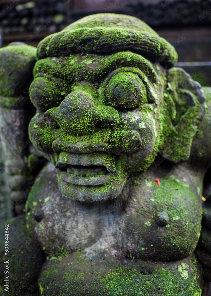 Sculpture of a deity covered with moss. Bali Indonesia Sculpture of a deity covered with moss. Bali Indonesia