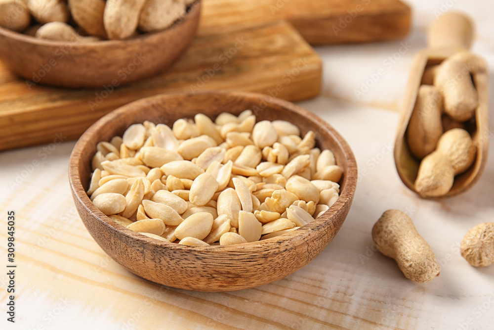 Plate with peanuts on white table Plate with peanuts on white table