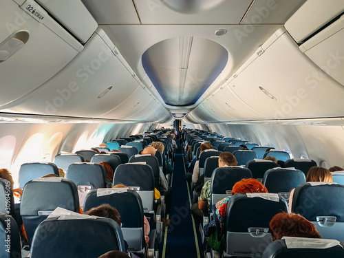 Airplane interior inside with passengers in flight.