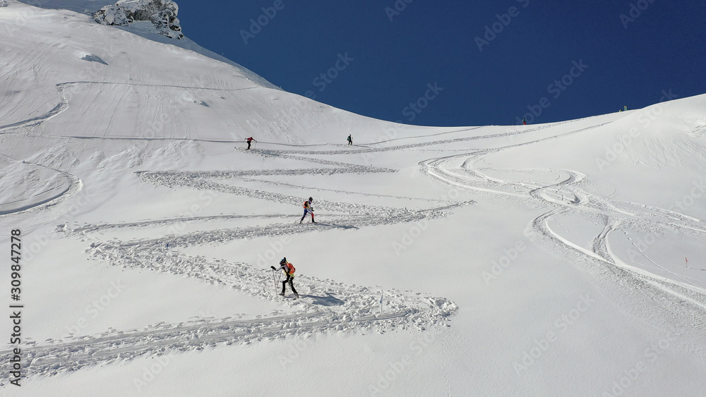 4k aerial photo with ski mountaineers competing during a ski touring race