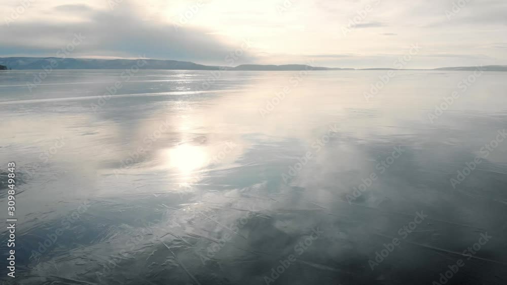 It's an aerial view. The winter landscape of the freezing river. The ice reflects the sky and the sun. Cold temperature. It's an aerial view. The winter landscape of the freezing river. The ice reflects the sky and the sun. Cold temperature.