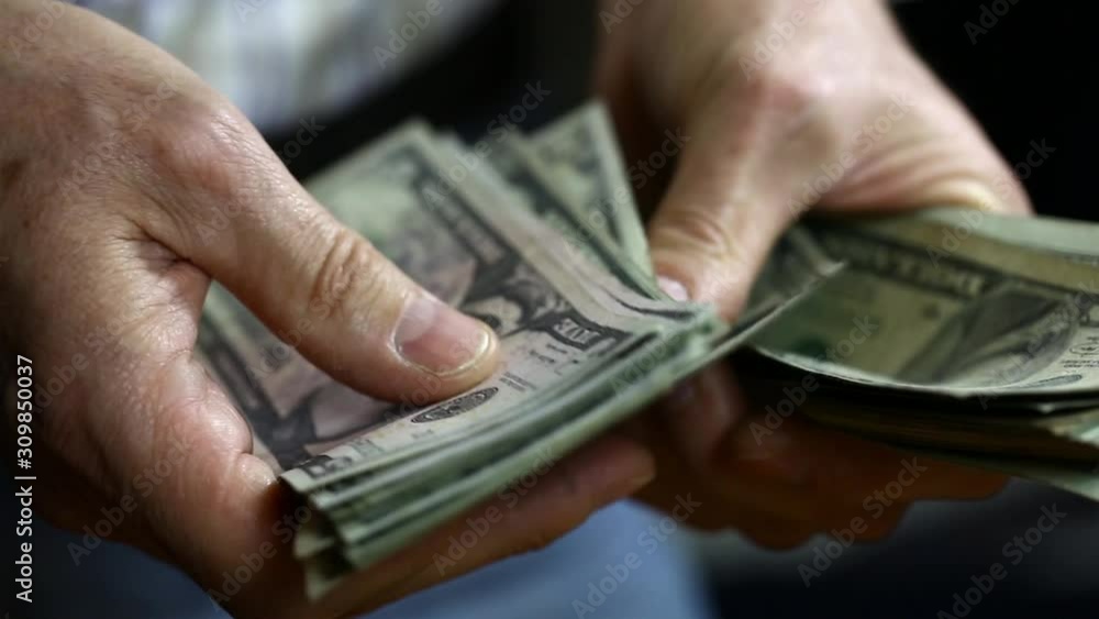 Man counting out dollar bills for an investment. Currency. Salary concept, shopping, buiness.