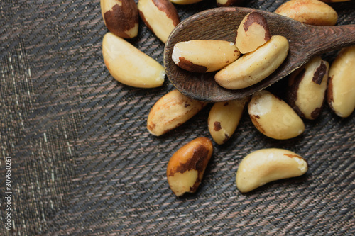 Brazilian nuts in a bowl on a wooden table. Kitchen background.