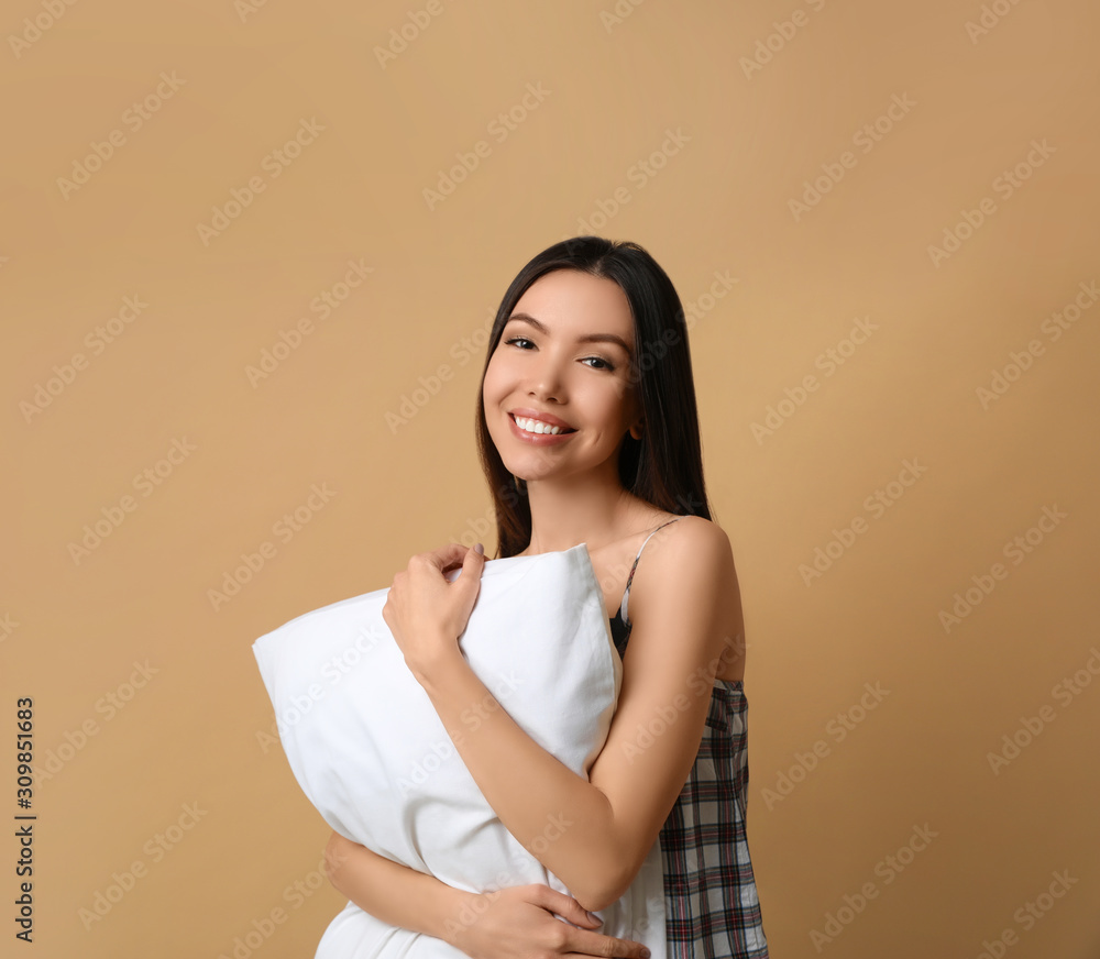 Beautiful Asian woman with pillow on beige background. Bedtime Beautiful Asian woman with pillow on beige background. Bedtime