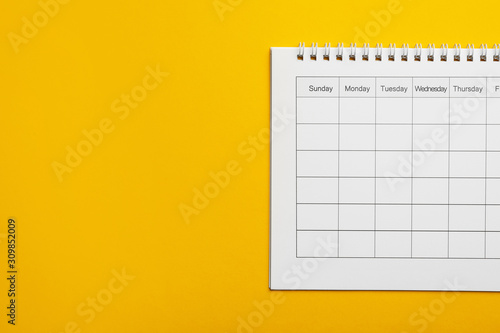 Blank calendar on yellow background, top view. Space for text