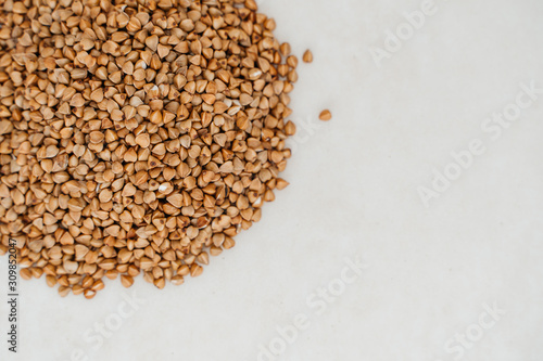 Handful of buckwheat on a white background close-up