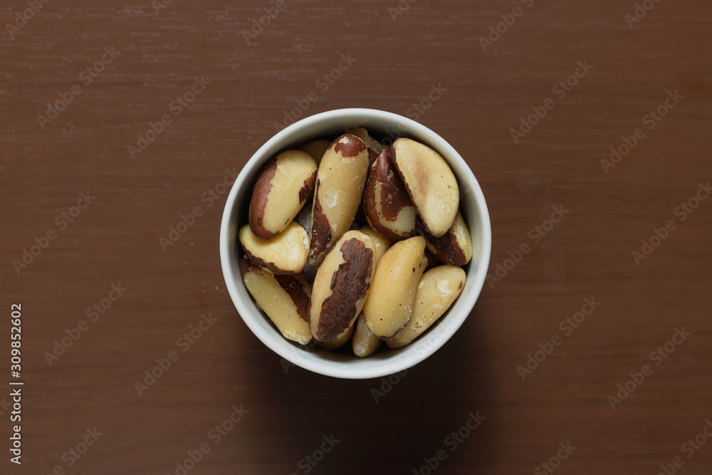 Brazilian nuts in a bowl on a wooden table. Kitchen background. Brazilian nuts in a bowl on a wooden table. Kitchen background.