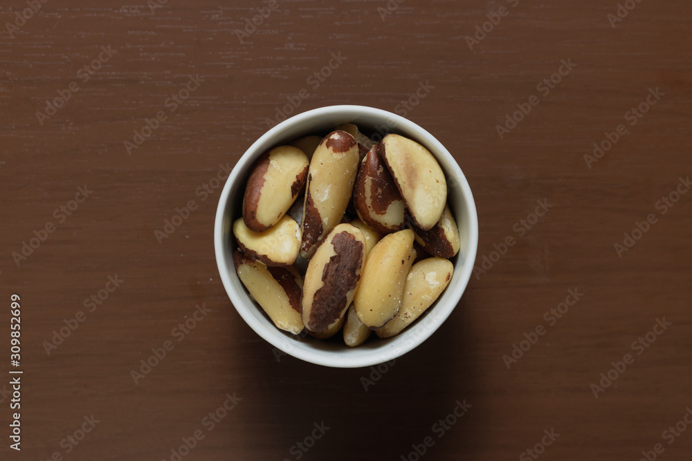 Brazilian nuts in a bowl on a wooden table. Kitchen background. Brazilian nuts in a bowl on a wooden table. Kitchen background.