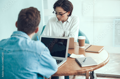 Young man and woman working together in office © Yakobchuk Olena