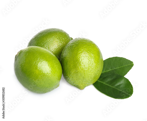 Fresh ripe limes with green leaves isolated on white